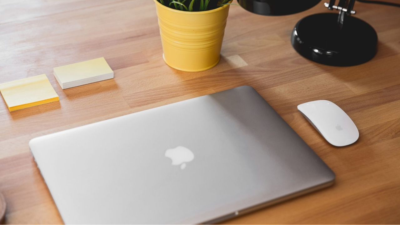 Notebook da Apple sobre uma mesa de madeira, representando propriedade intelectual e valor de marca